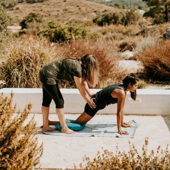 Deux femmes pratiquent des exercices de relaxation et étirements dans un cadre hôtelier serein proposé par Solal Events